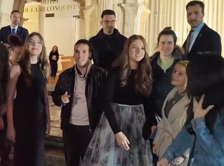 Plano medio de la Princesa Leonor e infanta Sofía haciéndose una foto con un grupo de fans en a la salida del Hotel Reconquista