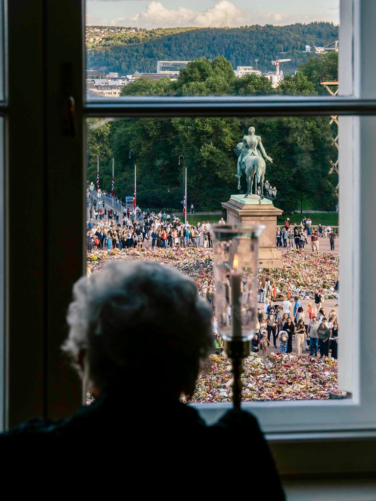 Astrid de Noruega observa la plaza del Palacio Real de Oslo y las decenas de flores depositadas por los noruegos en honor al rey Harald