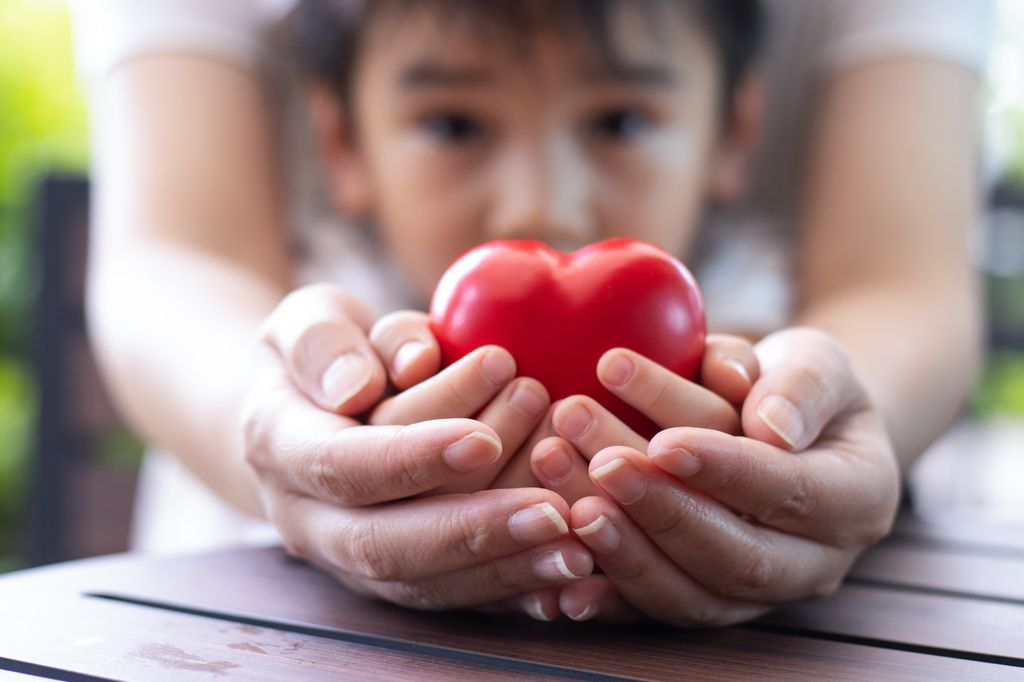Madre e hijo con un corazón en sus manos