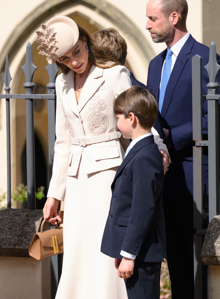 Kate Middleton con su hijo pequeño y de fondo el príncipe Guillermo