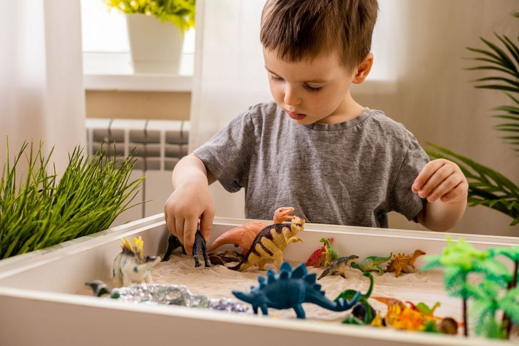 Niño jugando con dinosaurios