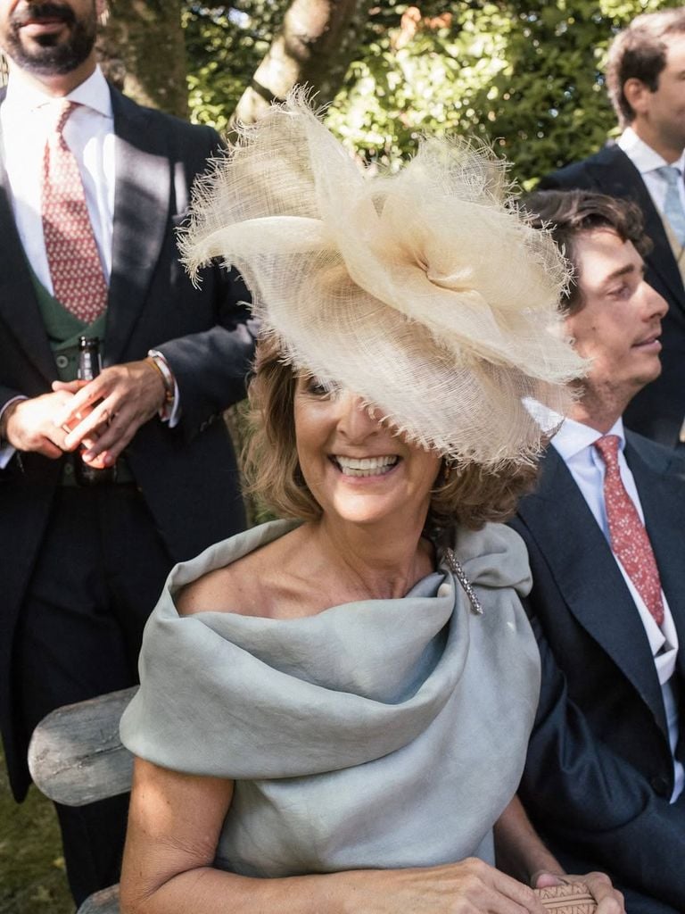 ​María, una madrina con vestido verde grisáceo con flores, de Sole Alonso, y tocado de rafia de Mimoki.