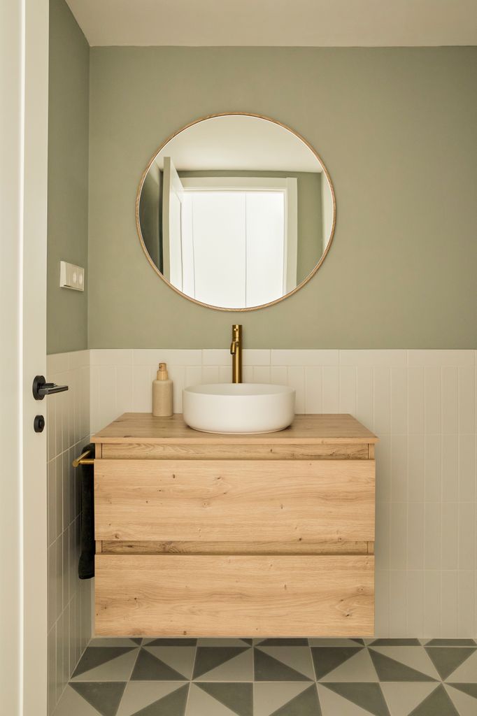 Baño con mueble de madera y revestimientos en blanco y verde
