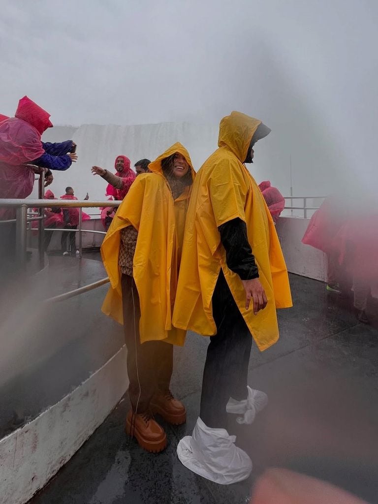Karla, protegiéndose del viento detrás del guardaespaldas de Alejandro Fernández.