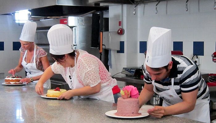 Los tres finalistas apuran los últimos segundos para dar los últimos toques a sus tartas.
