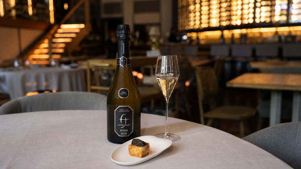 Botella de champán y bocado con caviar