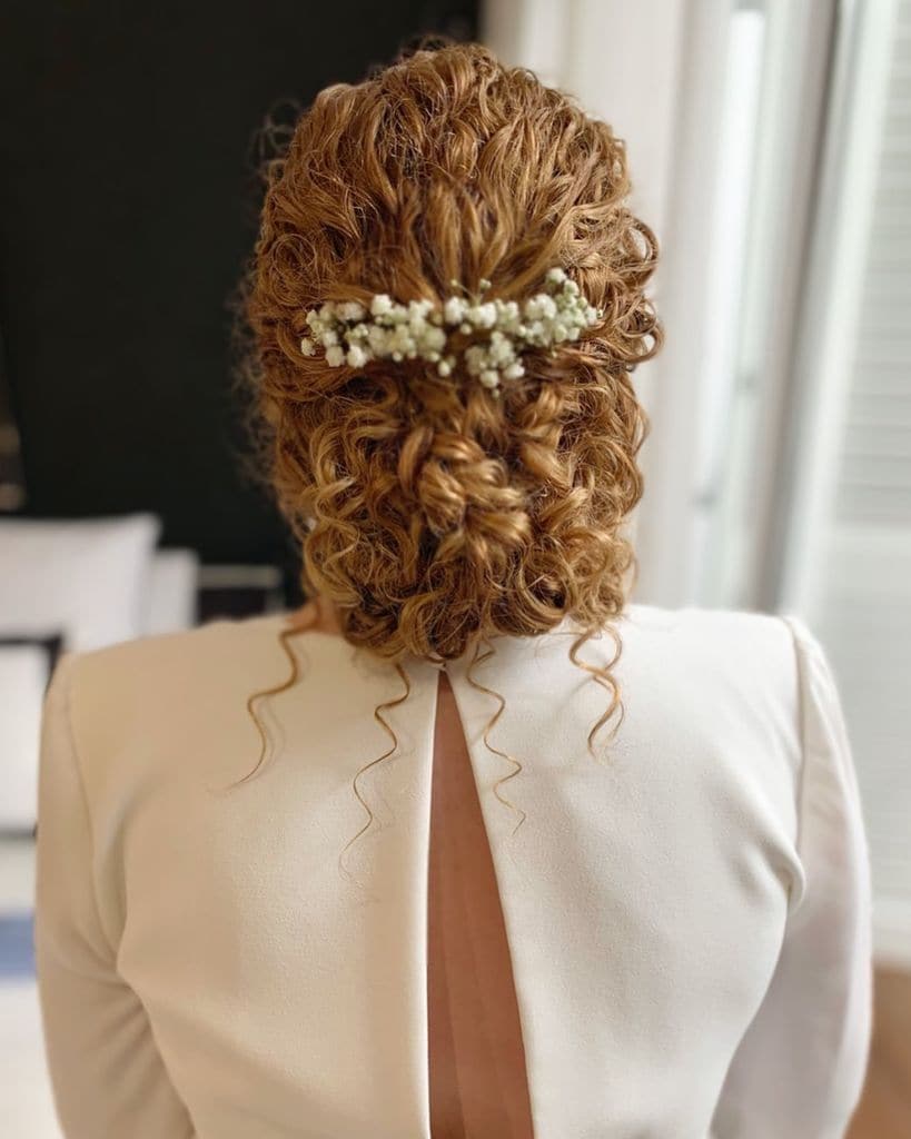 Peinados para novias con el pelo rizado moño con flores