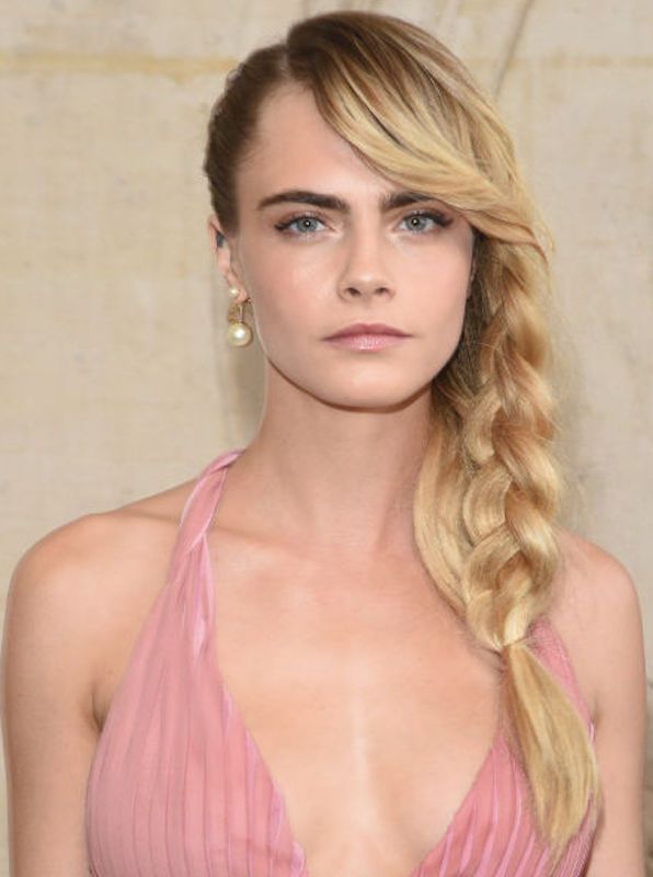 Cara Delevingne con trenza de un lado, natural makeup y vestido rosa 