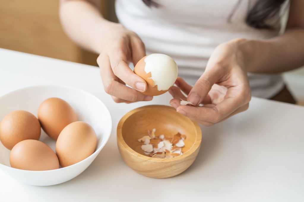 Mujer pelando huevos cocidos