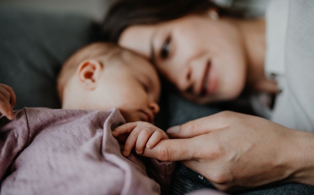 Madre feliz tumbada con su recién nacido