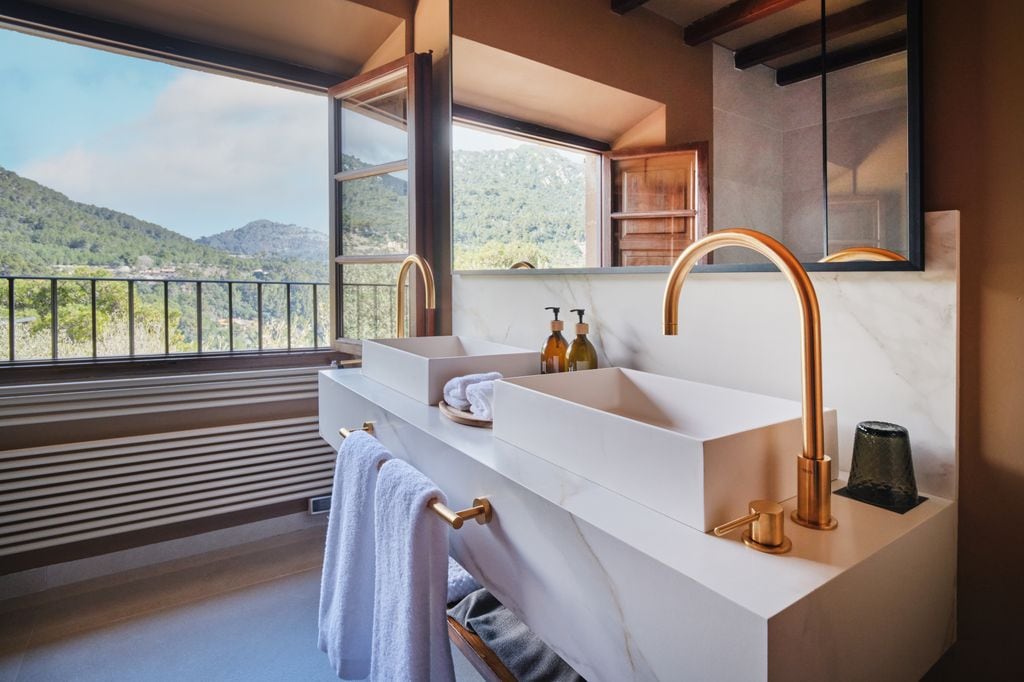 Baño con lavamanos cuadrados y griferías doradas
