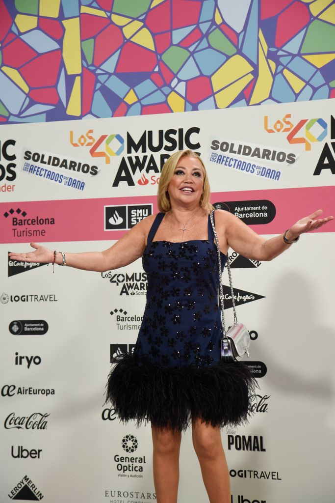 Plano medio de Belén Esteban con vestido azul marino con plumas y pedrería