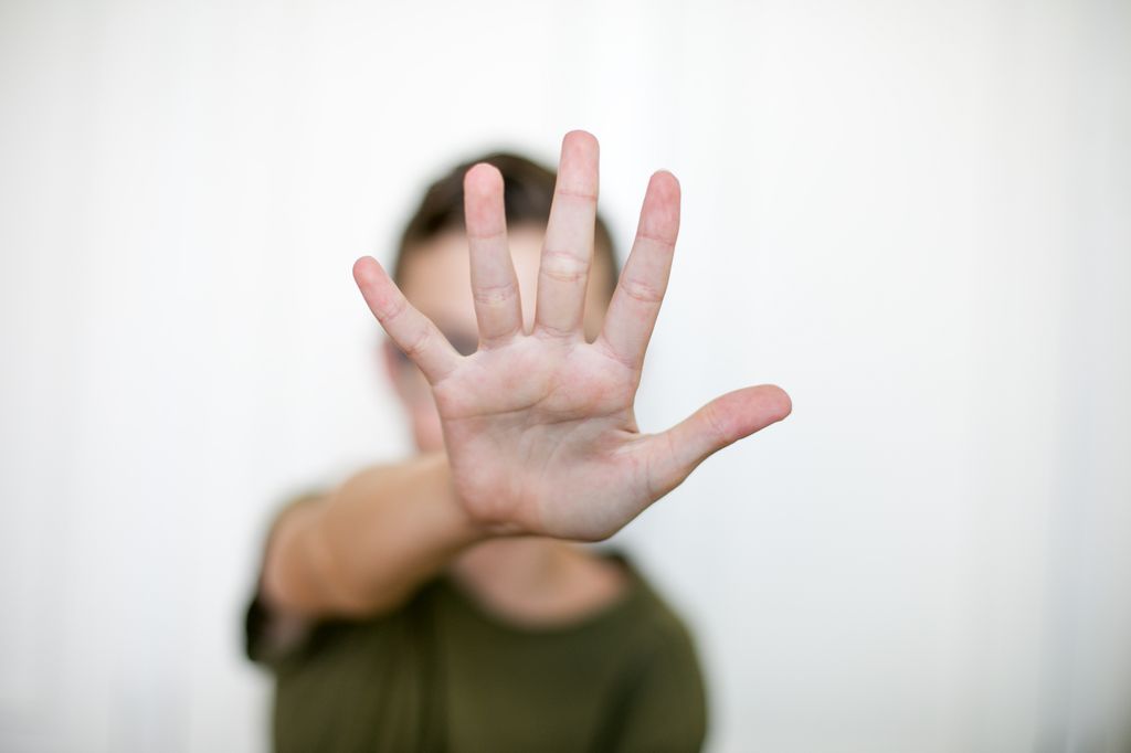 Adolescente con la mano en señal de stop