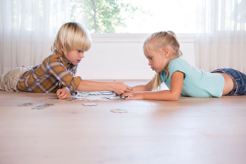 niños jugando con un puzle en el suelo