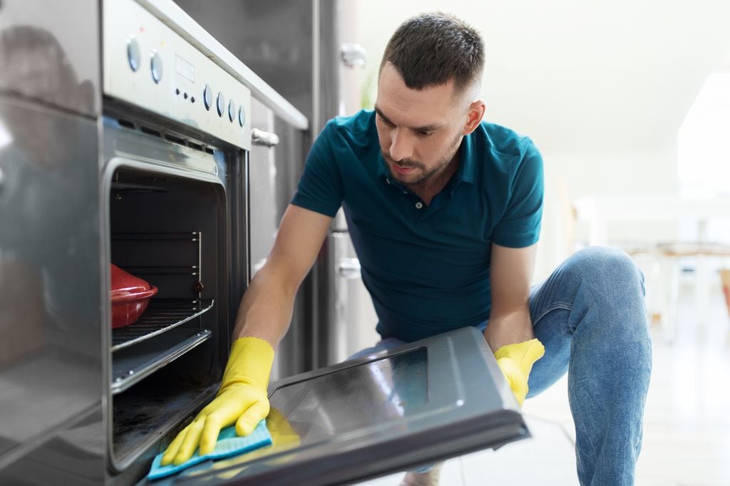 Hombre limpiando el horno.