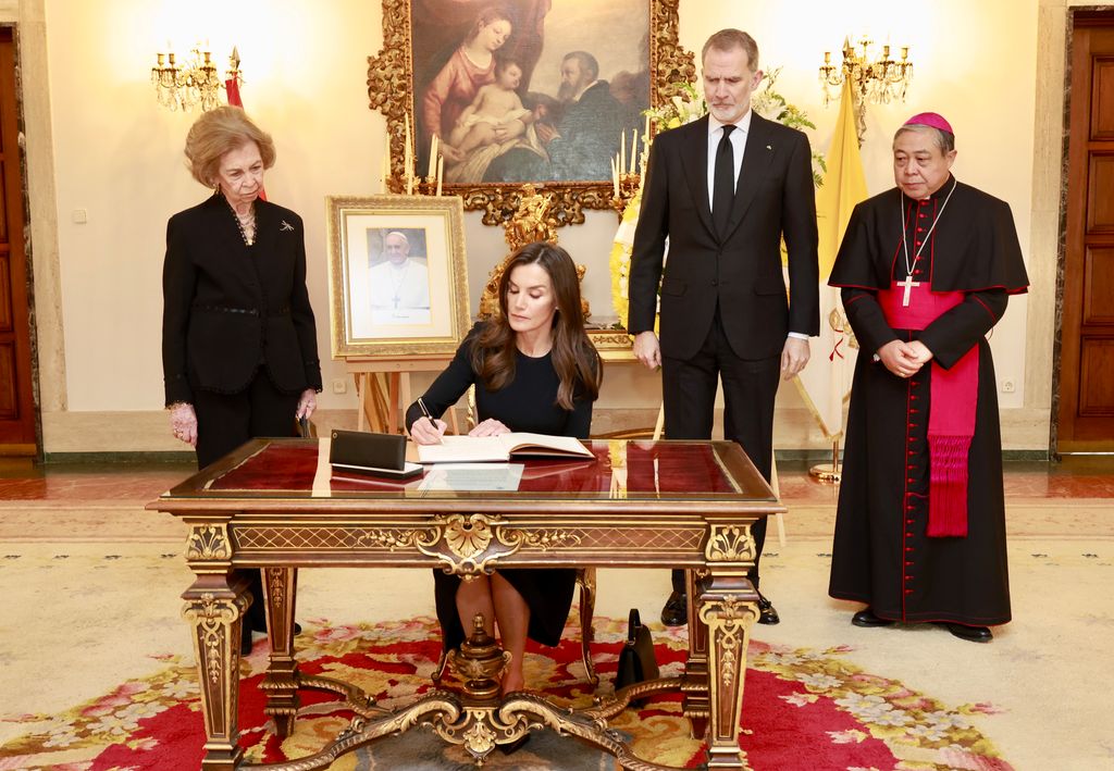 Los reyes Felipe y Letizia y la reina Sofía firmando en el libro de condolencias por el Papa Francisco 