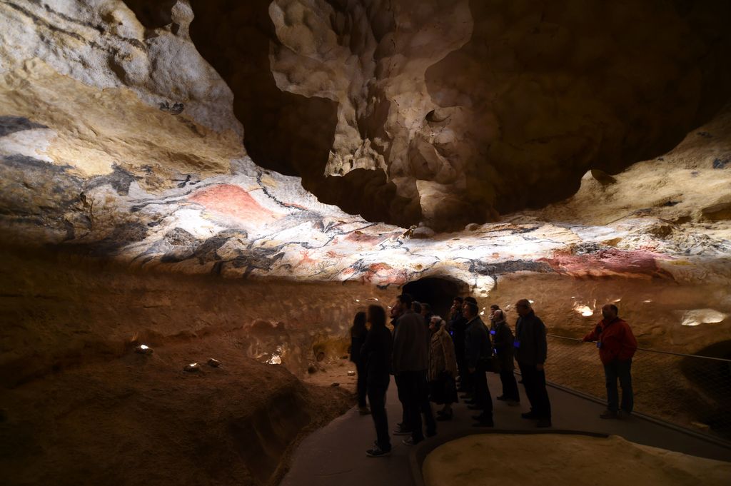 Visitantes recorren la nueva réplica de la cueva de Lascaux durante su apertura al público en 2016, una recreación que permite admirar el arte prehistórico sin dañar el original.