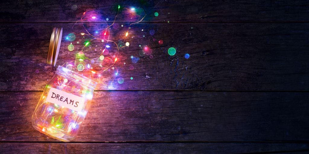 Bote con una etiqueta de sueños repleto de luces de colores