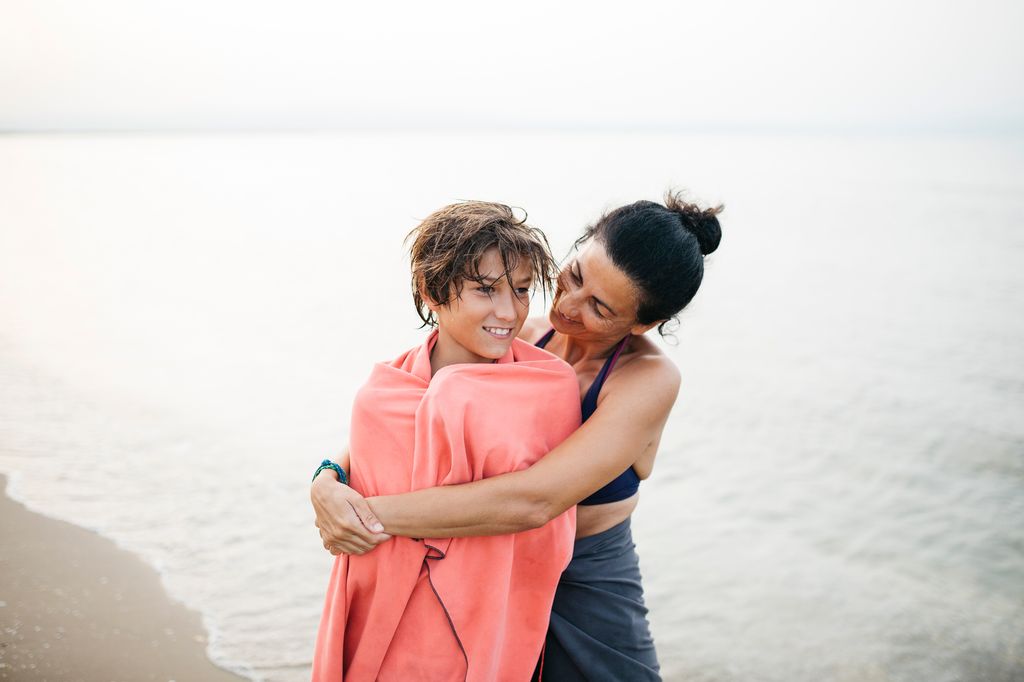 madre abrazando a su hijo en la playa