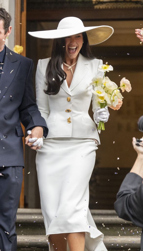 Dua Lipa con traje de dos piezas y pamela en su boda con Callum Turner en Londres, 2026.
