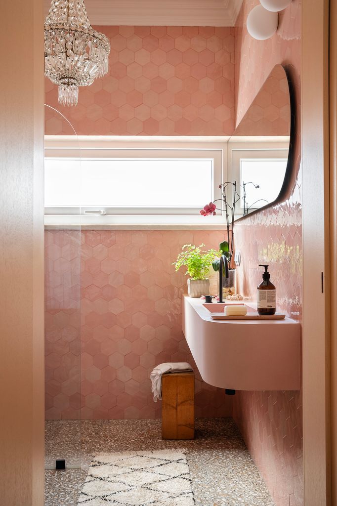 Baño rosa con lámpara de techo de cuentas de cristal