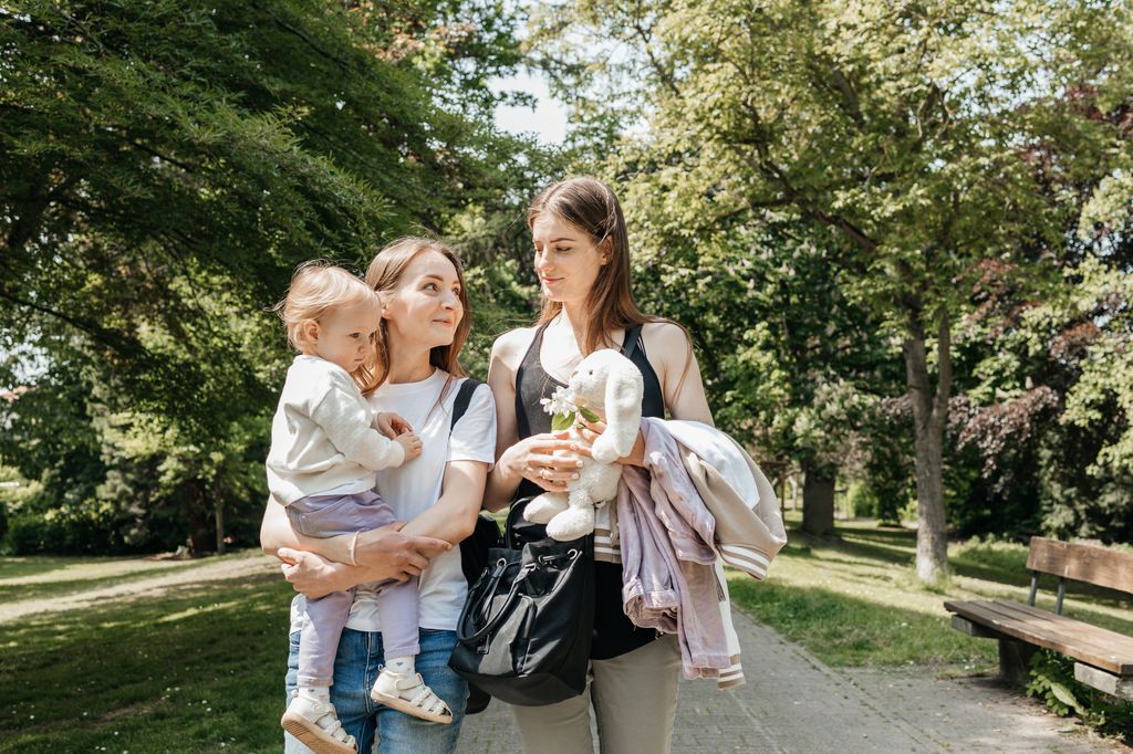 dos amigas paseando con un bebé en brazos