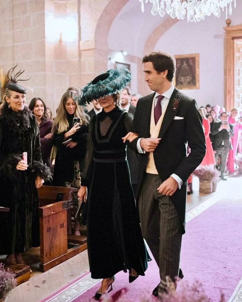 Vestido de madrina de Teresa Helbig y pamela de plumas de Conchitta