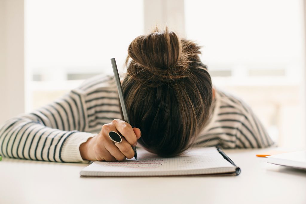 Chica adolescente sobrepasada delante de su libreta