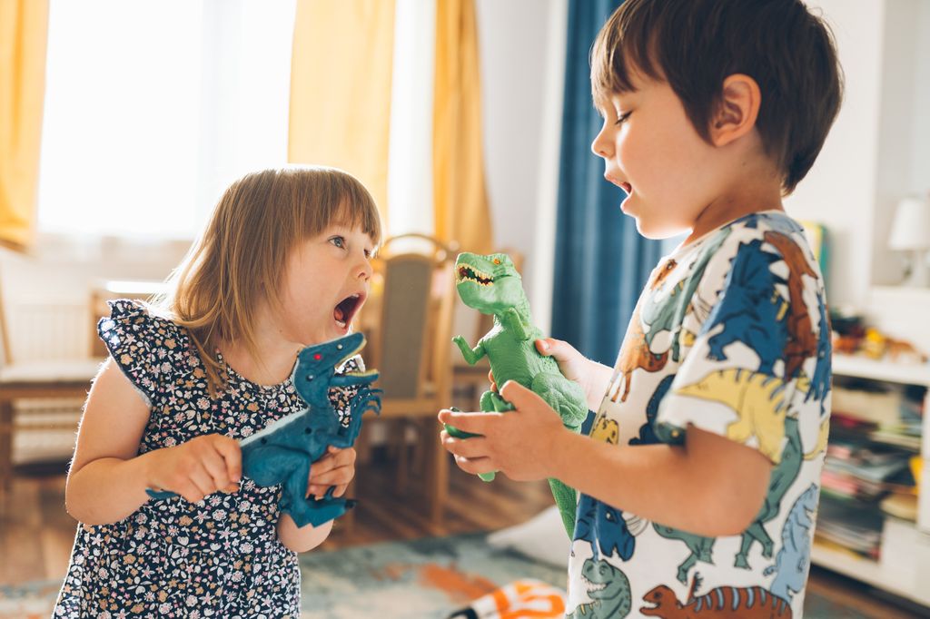 Niños pequeños jugando con dinosaurios