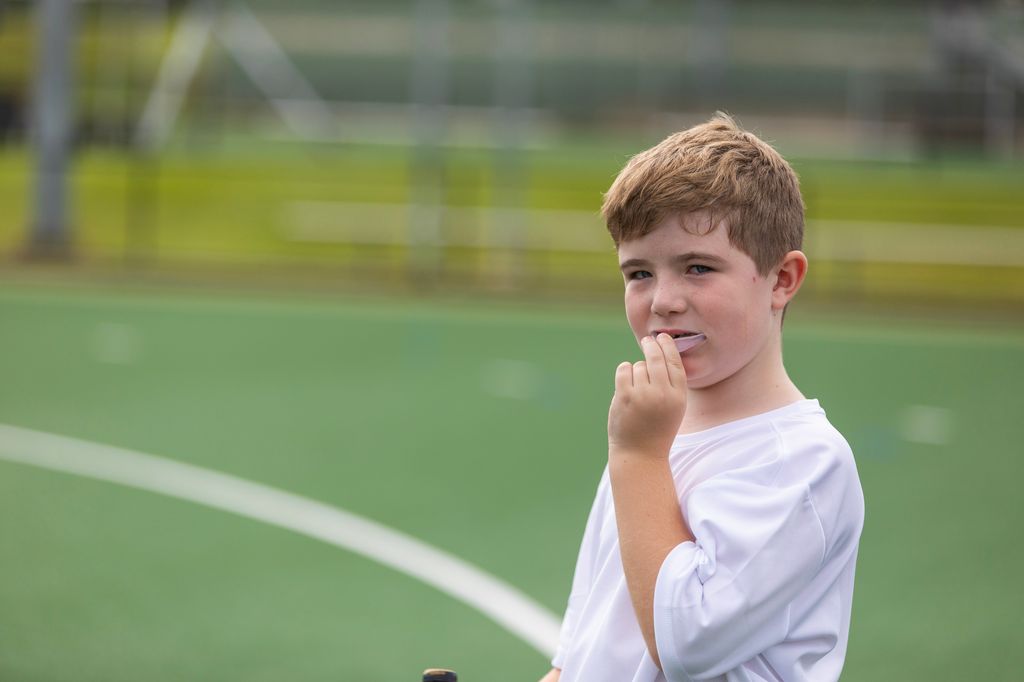 Niño con protector dental en un campo deportivo