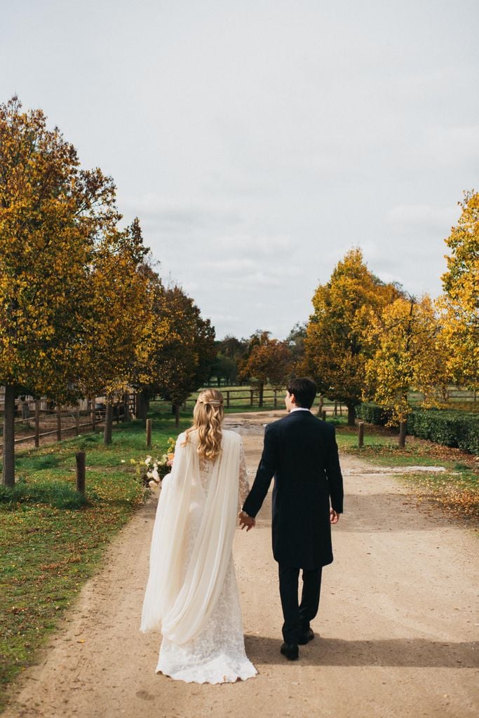 Plano entero de los novios de espaldas andando por el campo