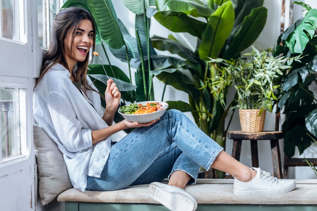 Mujer joven comiendo feliz
