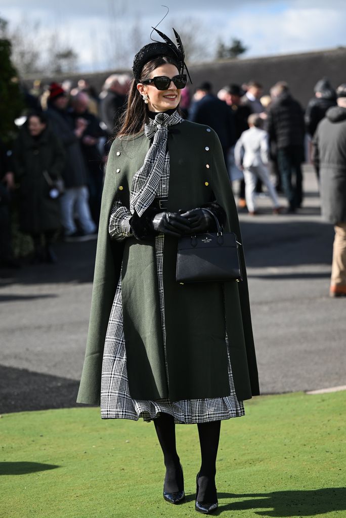 Look de invitada con abrigo capa en el Festival Cheltenham 2025