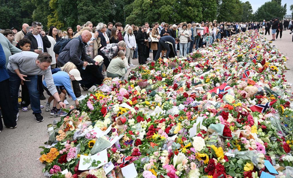 Las flores comienzan a cubrir la Plaza del Palacio Real de Oslo, donde numerosos ciudadanos se han acercado desde primera hora para rendir su particular homenaje a Harald V tras conocerse su muerte
