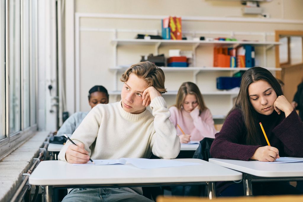 adolescente en clase, despistado, mirando por la ventana