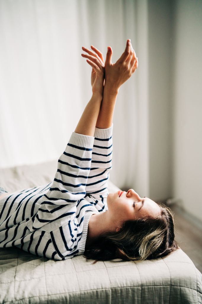 chica tumbada manos arriba