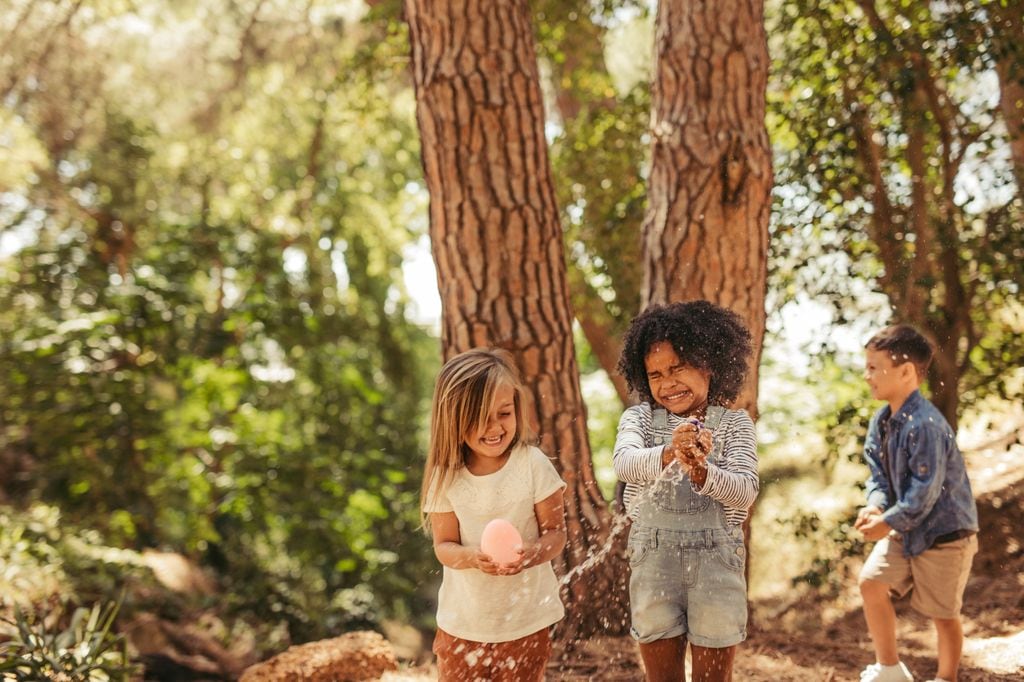 Niños jugando con globos de agua al aire libre