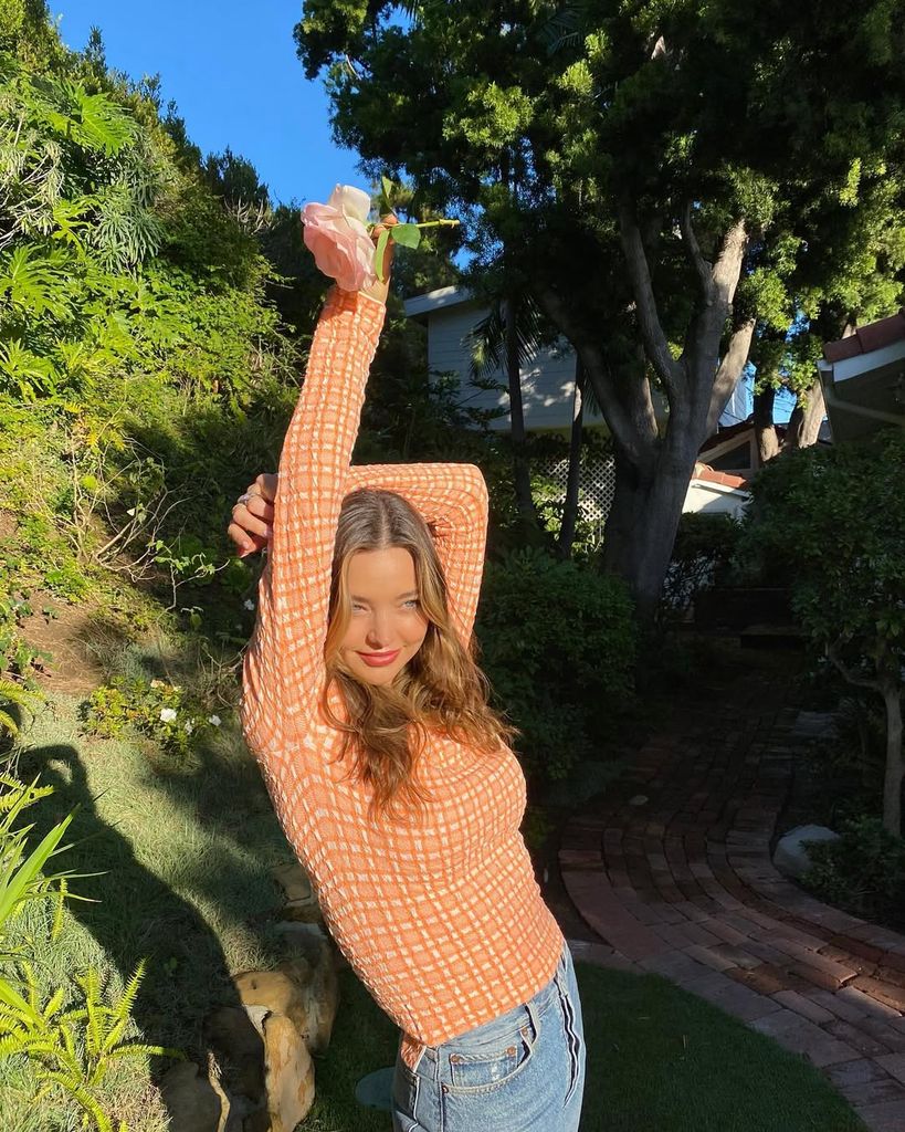 Miranda Kerr realizando estiramientos matutinos al aire libre en su rutina de bienestar
