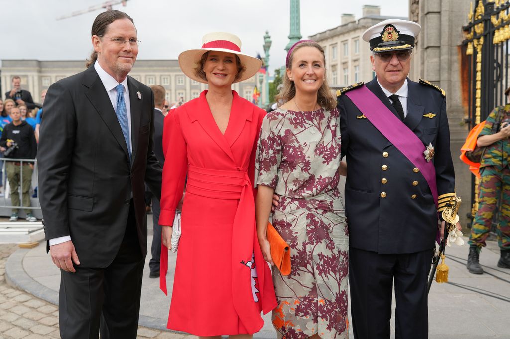 Plano medio de Delphine de Bélgica con Clara de Bélgica, James O'Hare y el príncipe Laurent