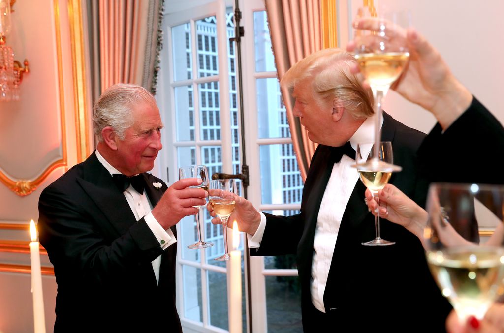 Plano medio de Carlos III con Donald Trump brindando durante una cena
