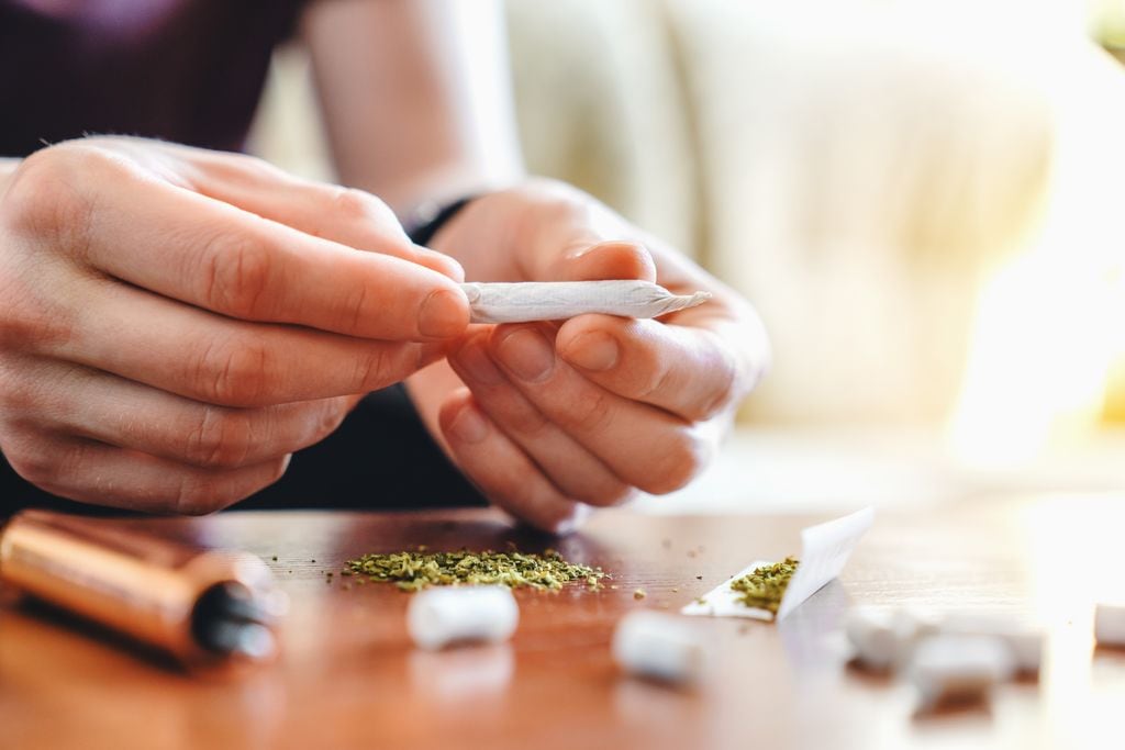 Adolescente preparándose un cigarro de marihuana