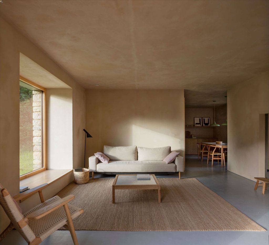 Salón situado en las antiguas cuadras de una cabaña pasiega en Cantabria reformada para lograr una mejora energética y en el confort de quienes la habitan