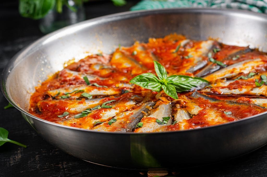 La salsa de tomate casera, con su toque de ajo y cebolla, aporta a las sardinas un sabor cálido y familiar.