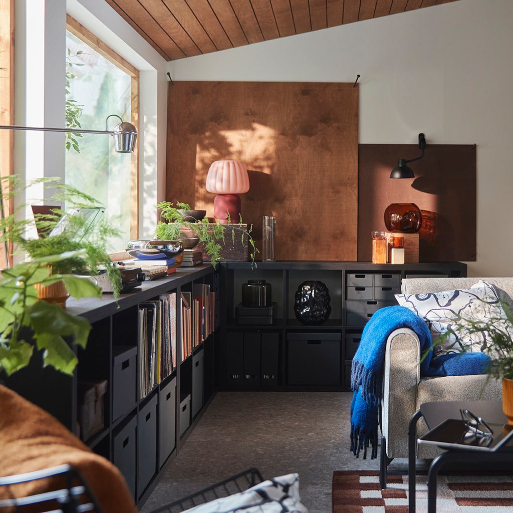 Salón con estantería negra bajo la ventana