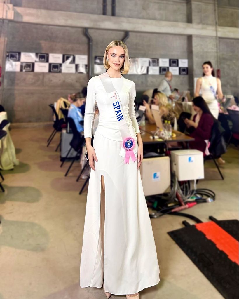 Plano medio de Alba Pérez con vestido largo blanco en un certamen