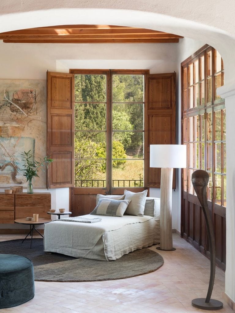 Rincón de lectura con ventanas de madera.