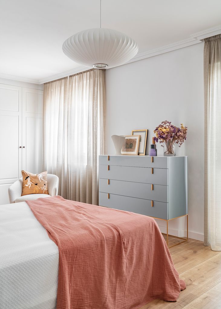 Dormitorio con cortinas tipo visillo.