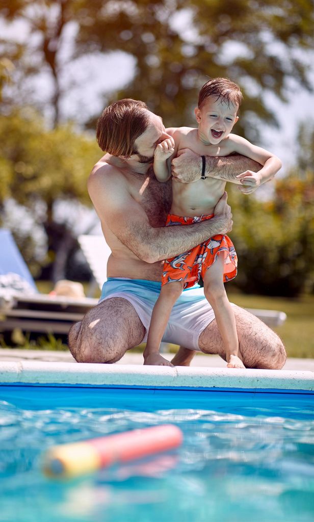 Padre e hijo divirtiéndose en la piscina