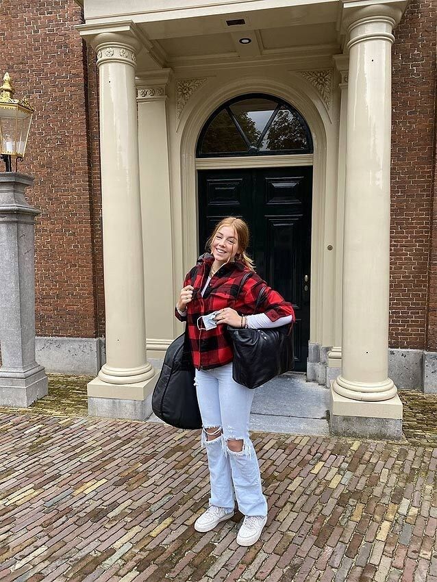 Plano entero de Alexia de Holanda con equipaje saliendo por una puerta