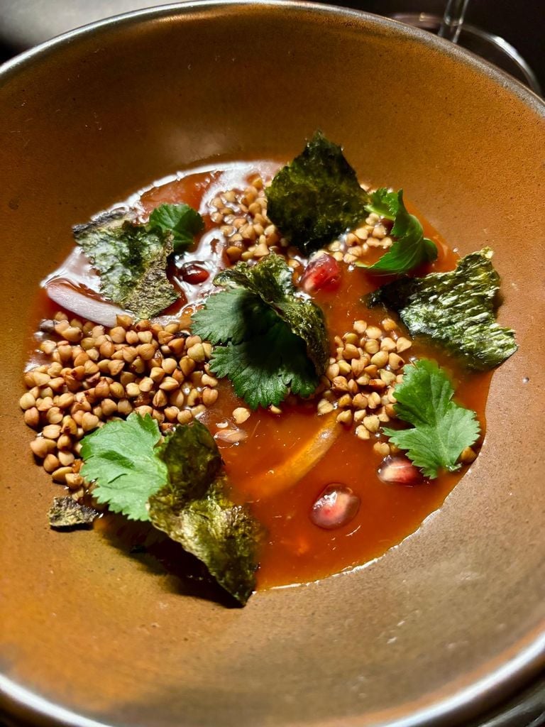 Ceviche de vieras con leche de tigre de kimchi, granola de trigo sarraceno, granada, alga gim tostada, cilantro y aceite de sésamo.